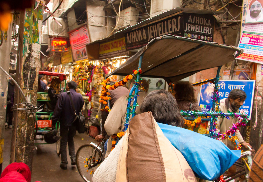 游客乘坐人力车游览印度德里历史悠久的昌德尼交汇处市场。